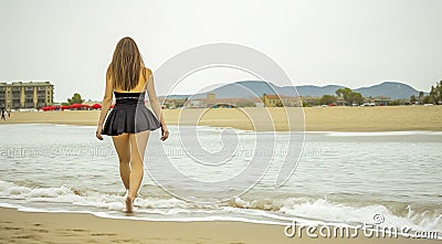 young girl on the beach, pretty girl walking on the beach, young woman running on the beach, backside view Stock Photo