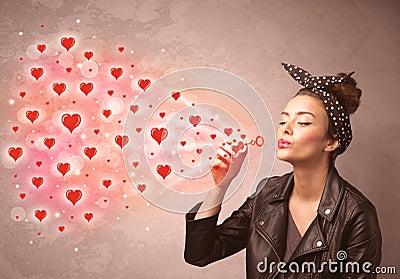 Pretty young girl blowing red heart symbols Stock Photo