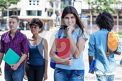 Pretty young hispanic female student with group of young adults Stock Photo