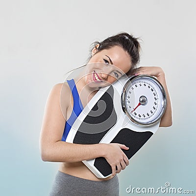 Pretty young lady holding her scales happy with weight Stock Photo