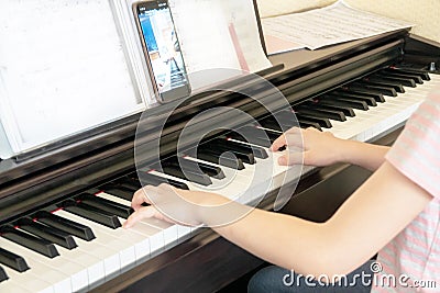 Pretty young musician playing classic digital piano at home during online class at home, social distance during quarantine, self- Stock Photo