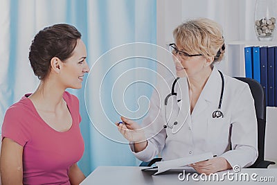 Young patient in medical office of helpful senior female doctor Stock Photo
