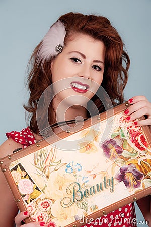 Pretty young retro styled female with beauty case Stock Photo