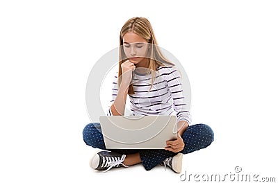 Pretty young teen girl sitting on the floor with crossed legs and using laptop, isolated Stock Photo