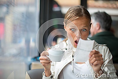 Pretty, young woman baffled with the bill in a coffeeshop Stock Photo