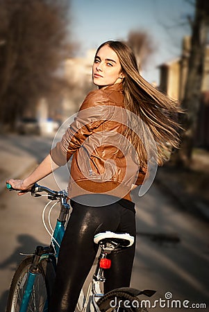 Pretty young woman with bicycle in a city road Stock Photo