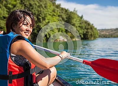 Pretty, young woman on a canoe on a lake Stock Photo