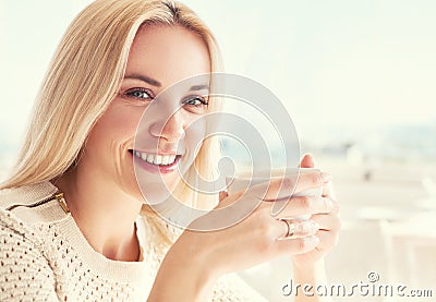 Pretty young woman with cup of coffee in sunny restaraunt Stock Photo