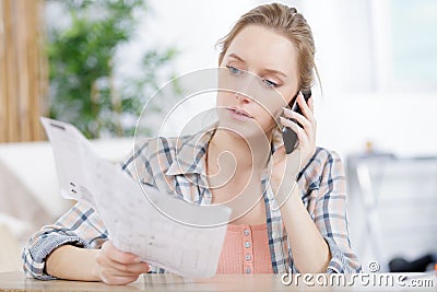 pretty young woman doing diy and talking on phone Stock Photo