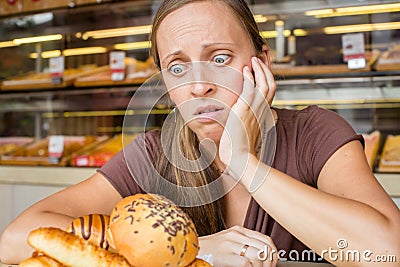 Pretty young woman eating sweets in the cafe. Bad habits. Health Stock Photo