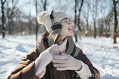 Pretty young woman enjoy winter day with music Stock Photo
