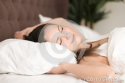 Pretty young woman enjoys long sleep in bed Stock Photo