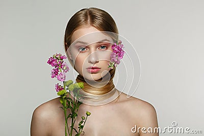 Pretty young woman with fresh spring look, wonderful hair, nice makeup, flowers near her face and in hair Stock Photo