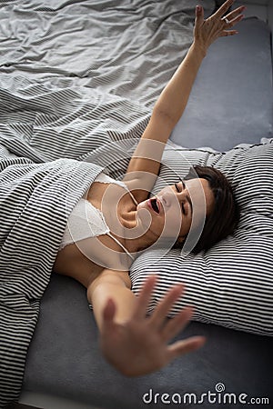 Pretty, young woman in her bed, waking up refreshed in the morning after a good night sleep Stock Photo