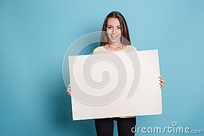 Pretty young woman holding empty blank board over blue background Stock Photo