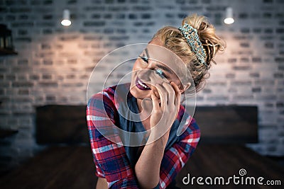 Pretty young woman sits on the bed in stylish bedroom. Russian blonde girl Stock Photo