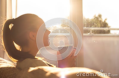 Girl enjoying morning coffee in living room Stock Photo