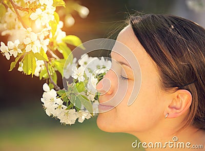 Pretty young woman smells flower Stock Photo