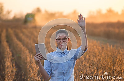 Farmer girl with tablet and combine harvester Stock Photo