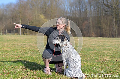 Pretty young woman teaching her dog commands Stock Photo