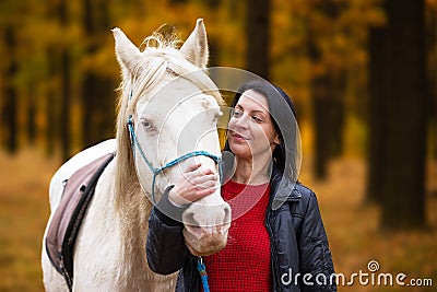 A pretty young woman and a white horse it's the love of a lifetime Stock Photo