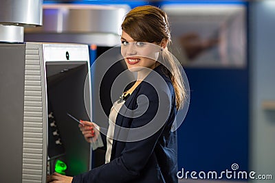 Pretty, young woman withdrawing money from her credit card Stock Photo