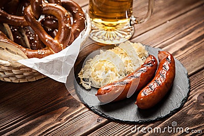 Pretzels, bratwurst and sauerkraut on wooden table Stock Photo