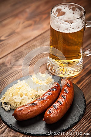 Pretzels, bratwurst and sauerkraut on wooden table Stock Photo