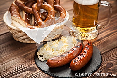 Pretzels, bratwurst and sauerkraut on wooden table Stock Photo