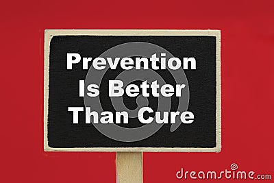 Prevention Is Better Than Cure on a chalkboard against red background Stock Photo