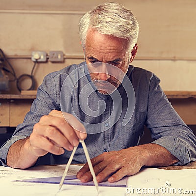 He prides himself on his accuracy. a draftsman using a triangle and compass to draw up building plans. Stock Photo