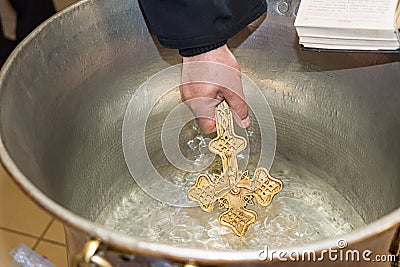 The priest blesses Christening Baptismal Font filled with Holy Water at the church during the ceremony Stock Photo