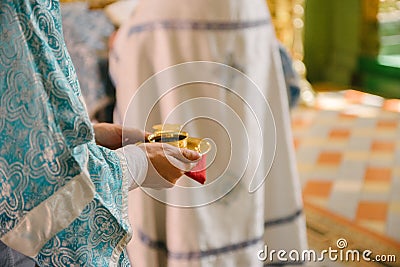 The priest in the church holds the wedding rings at the wedding Stock Photo