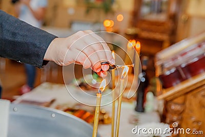 Priest hand burning hair in candle light at church Stock Photo