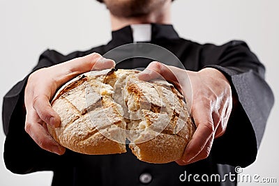 Priest holding loaf of bread Stock Photo