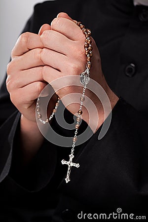 Priest is holding rosary Stock Photo