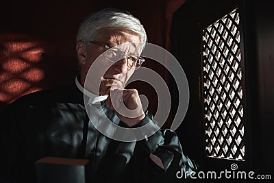 Priest listening to the confession Stock Photo