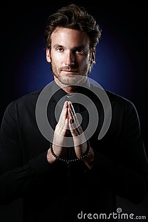 Priest praying with rosary Stock Photo