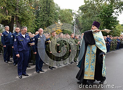 The priest sprinkles with holy water the cadet before academic year. Editorial Stock Photo