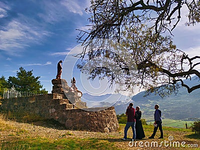 A priest and two faithful praying in front of the Pindreau monument, place of the Marian apparition of Our Lady of Laus. Editorial Stock Photo