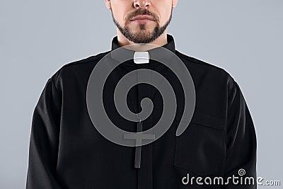 Priest wearing cassock with clerical collar on grey, closeup Stock Photo