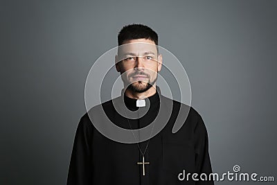 Priest wearing cassock with clerical collar on grey background Stock Photo