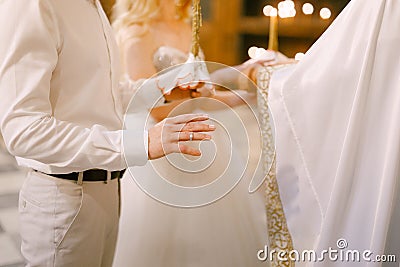 A priest in a white habit marrying the bride and groom in the church of St. Nicholas in Kotor Stock Photo