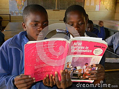 Primary school girls reading Mathematics textbook in class Editorial Stock Photo