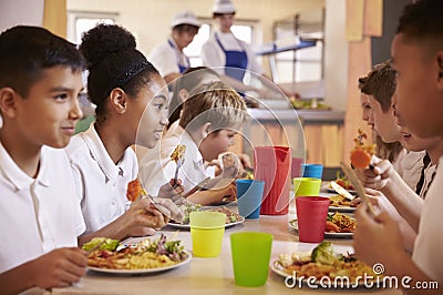Primary school kids eat lunch in school cafeteria, close up Stock Photo