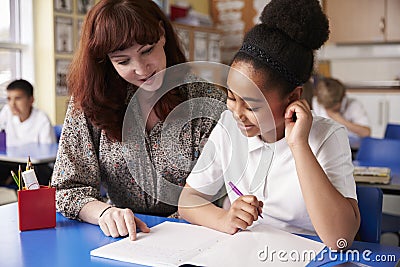 Primary school teacher with a schoolgirl in class, close up Stock Photo