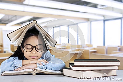 Primary student reading textbook in classroom Stock Photo