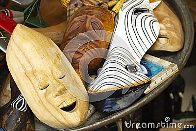 Primitive wooden masks, in the foreground a smiling face, selective fokus Stock Photo