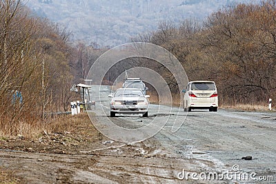 Primorsky Krai, Russia - 2016, autumn - A car drives along a bad, dead road among tall trees. Russian roads. Bad asphalt Editorial Stock Photo