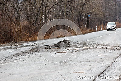 Primorsky Krai, Russia - 2016, autumn - A car drives along a bad, dead road among tall trees. Russian roads. Bad asphalt Editorial Stock Photo